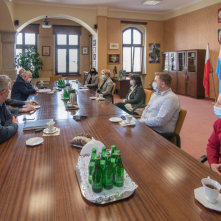Delegacja z Bolesławca rozmawia z zastępcą prezydenta Zbigniewem Fiderewiczem przy stole w sali w budynku Urzędu Miasta