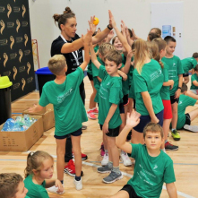Na zdjęciu: dzieci w zielonych koszulkach po zawodach sportowych