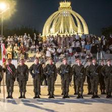 Na zdjęciu żołnierze stoją na baczność, za nimi uczestnicy wydarzenia
