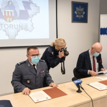 Na zdjęciu rzeczniczka KMP w Toruniu fotografuje porozumienie