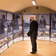 Na zdjęciu: oficer policji patrzy na plansze na wystawie poświęconej historii policji
