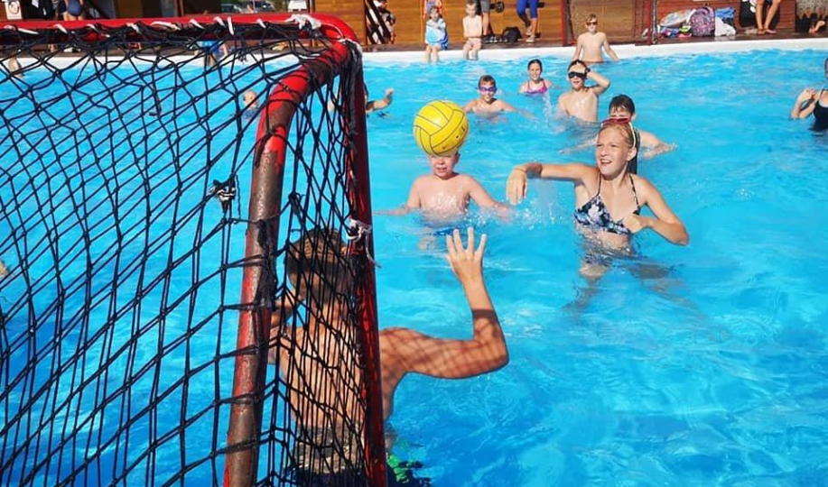 Na zdjęciu widać dzieci grające w piłkę wodną na basenach letnich Na Skarpie