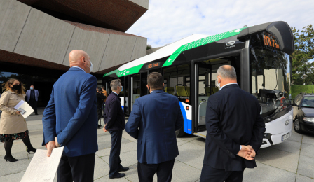 Na zdjęciu prezydent Michał Zaleski oraz uczestnicy wydarzenia oglądają autobus elektryczny z zewnątrz