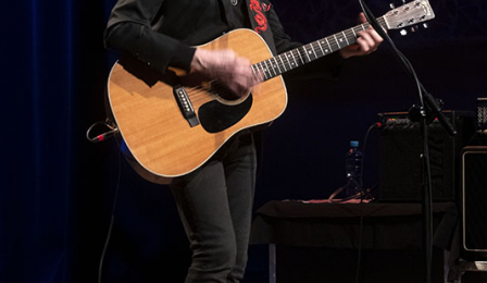 John Porter gra na gitarze i śpiewa na scenie CKK