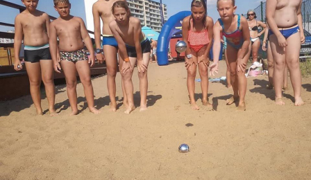 Zdjęcie przedstawia dzieci grające w boule