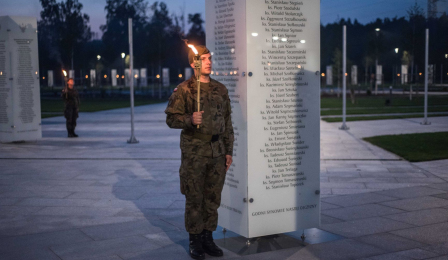Na zdjęciu żolnierz z pochodnią przy tablicy w Parku Pamięci Narodowej